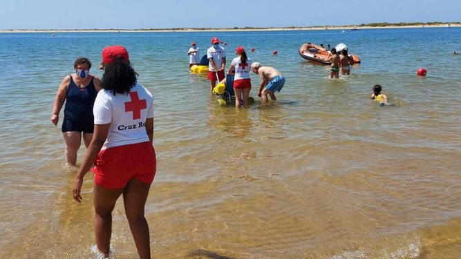 Varios voluntarios de Cruz Roja en una jornada de playa con discapacitados.