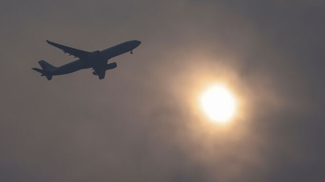 Vista de un avión y del sol entre la contaminación  del aire.