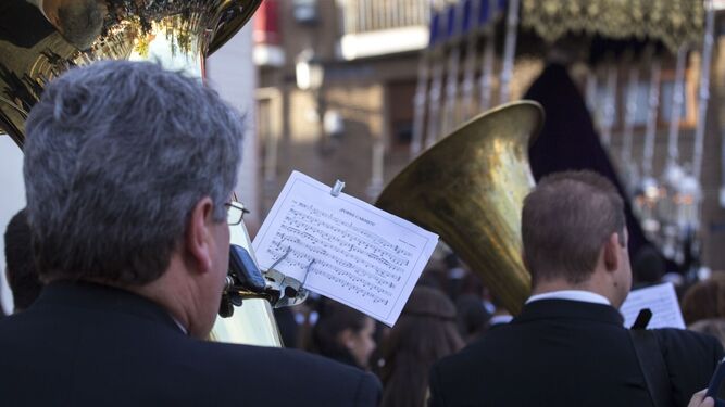 Una Banda de Música toca tras un palio durante una procesión.