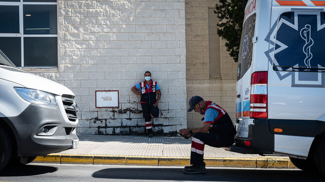 Dos sanitarios descansan junto a una ambulancia en los exteriores del Hospital Juan Ramón Jiménez.