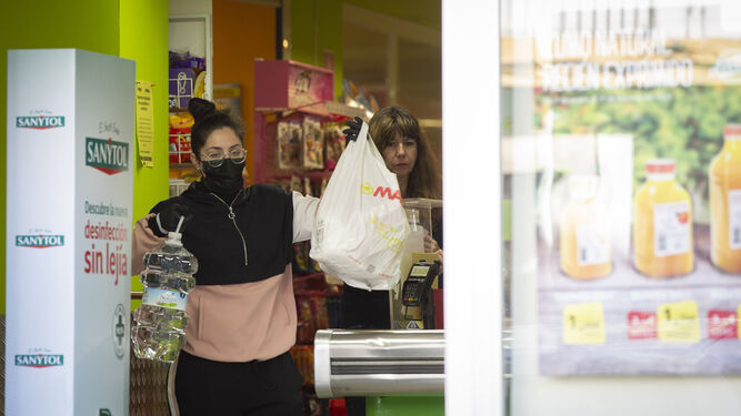Una joven sale del supermercado tras hacer la compra