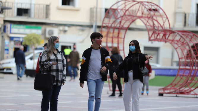 Un grupo de jóvenes con mascarilla pasea por la Plaza de las Monjas, uno de los espacios más reconocidos del centro de la capital onubense.