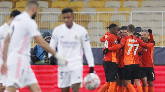 Los madridistas Benzema y Rodrygo, cabizbajos mientras los jugadores del Shakhtar celebran el primer tanto del encuentro.