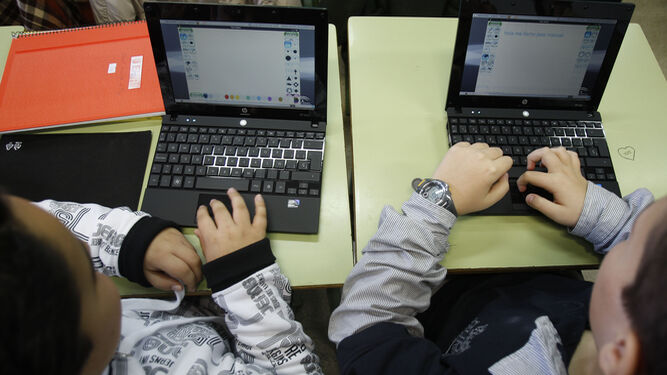 Escolares haciendo uso de ordenadores en el aula