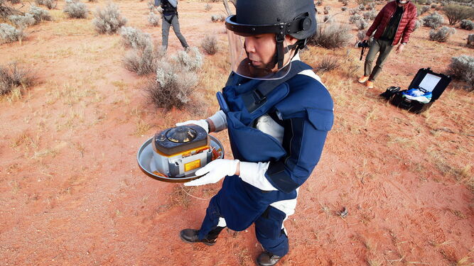 Un técnico sostiene la cápsula con muestras del asteroide