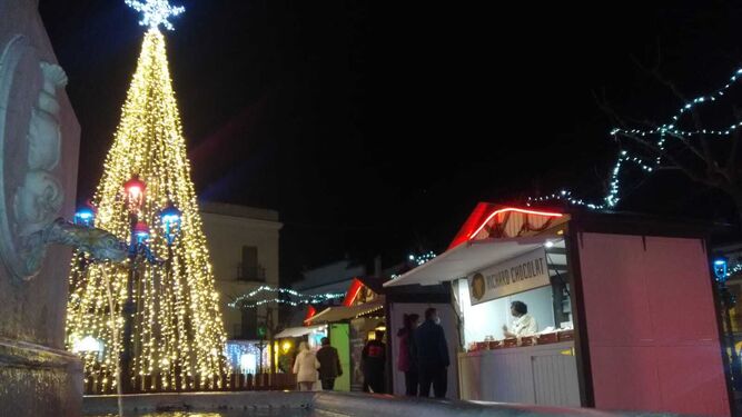 Vista parcial de la plaza con decoración navideña y los puestos de artesanía del mercado.