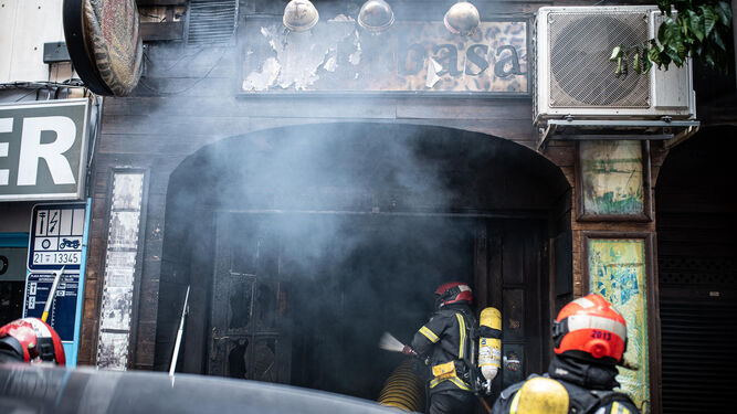 Varios miembros del Cuerpo de Bomberos en pleno operativo para extinguir el incendio en el bar Mombasa de la capital.
