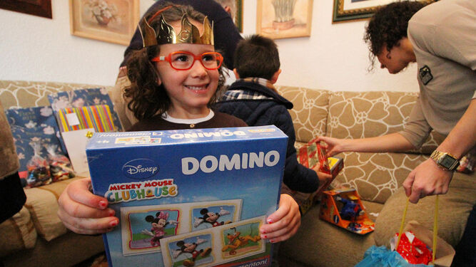 Una niña enseña feliz su regalo en la mañana de Reyes