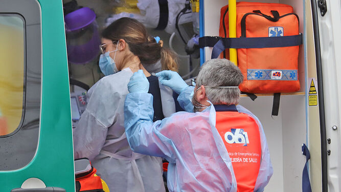 Un sanitario coloca un traje protector en una ambulancia.