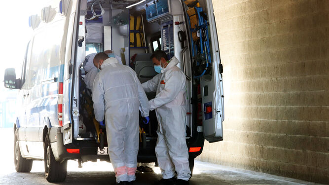 Dos sanitarios atienden en una ambulancia en las inmediaciones del Hospital Juan Ramón Jiménez.