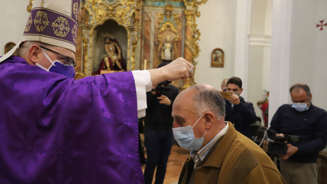 El obispo lanza la ceniza sobre uno de los fieles, según marca el nuevo protocolo