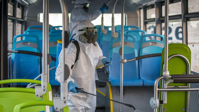 Dos operarios desinfectan un autobús de Emtusa.