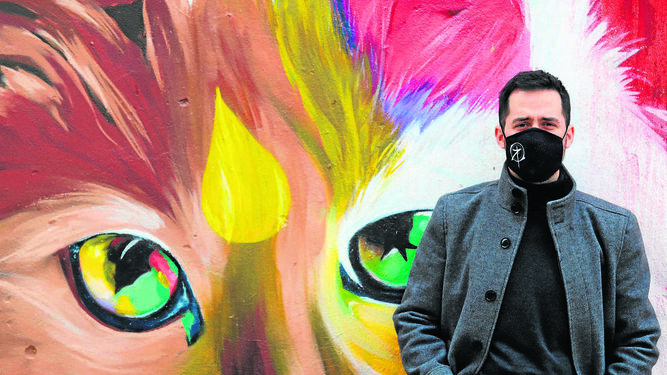 Víctor Romero ante una de sus obras protagonizadas por un colorido gato.