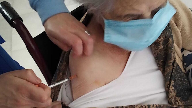 Una anciana se vacuna contra la Covid-19 en el asilo de Nerva.