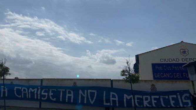 Entrada a la Ciudad Deportiva con la pancarta criticando a los jugadores.