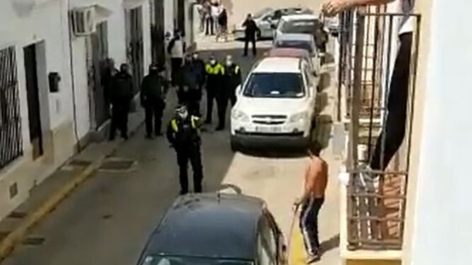 Fotograma del vídeo en el que se puede ver al detenido sin camiseta, rodeado por los agentes antes de la detención.icía fuera de servicio en Moguer
