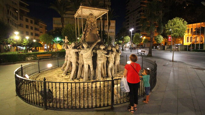 Una mujer y un niño, ante el monumento a la Virgen del Rocío en Huelva.