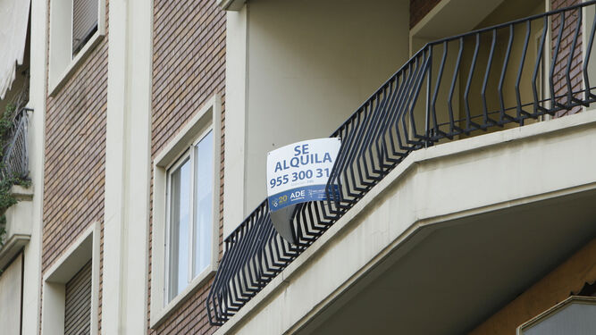 Cartel con el anuncio de un alquiler en un balcón de una vivienda.