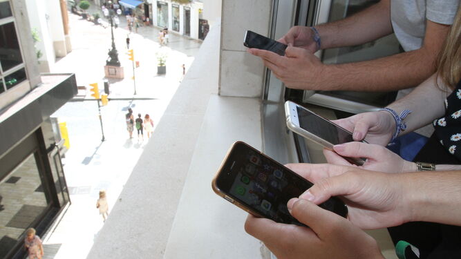 Un grupo de jóvenes atiende sus redes sociales en sus móviles.