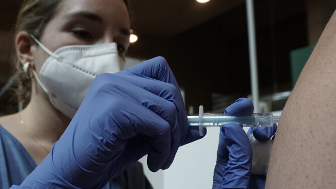 Detalle del momento en el que una enfermera inyecta la vacuna contra el coronavirus en el Estadio de la Cartuja.