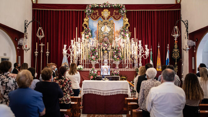 El Simpecado de la concha peregrina en su altar rodeado de luces y flores en la misa de romero con la que se inició todo.
