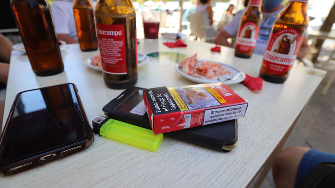 Cajetilla de tabaco sobre una mesa en una terraza de un bar.