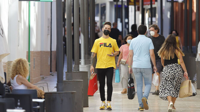 Un joven pasea por el centro de Huelva con su mascarilla.
