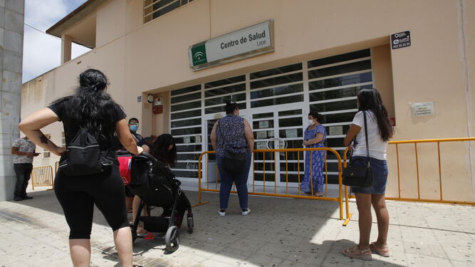 Varias personas guardan cola en la puerta del centro de salud de Lepe.