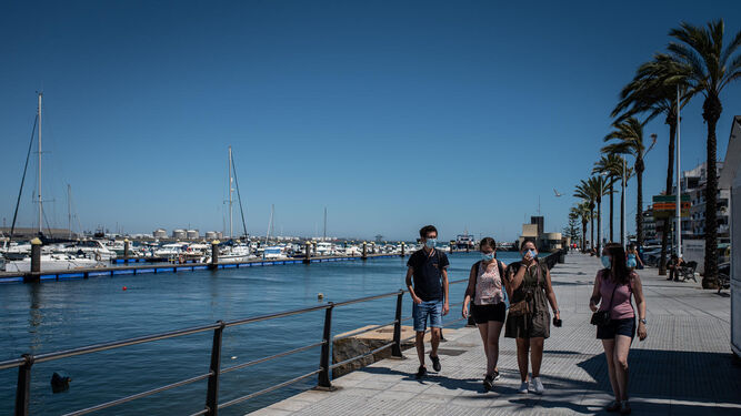 Un grupo de jóvenes pasea por Punta Umbría con sus mascarillas.
