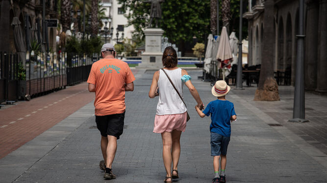 Tres personas pasean por el centro de Huelva.