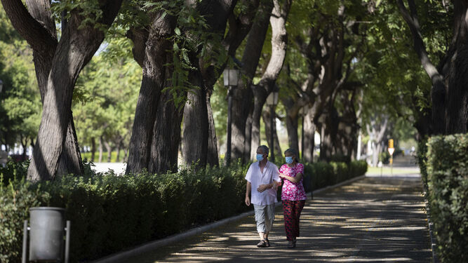 Dos onubenses pasean por la Avenida Andalucía de la capital.