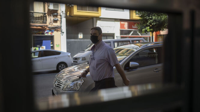 Un hombre pasea con su mascarilla por una calle de Huelva.