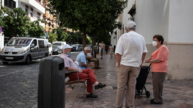 Un grupo de personas conversa con sus mascarillas en una calle del centro de Huelva durante el día de ayer.