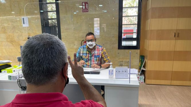 Uno de los trabajadores de Aguas de Huelva atendiendo a una persona sorda con la nueva mascarilla.