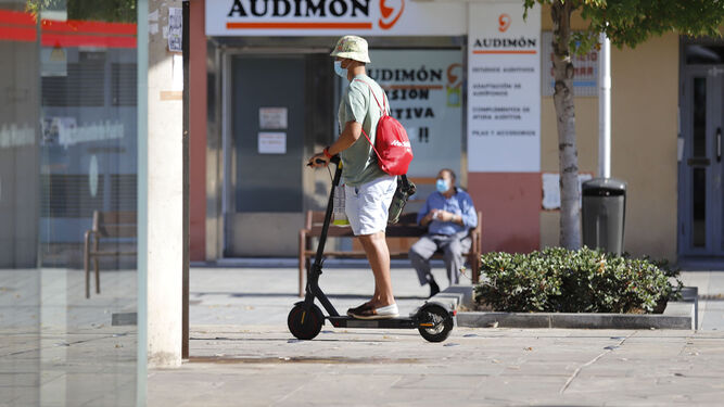 Un ciudadano pasa en monopatín junto al Mercado del Carmen durante la mañana de ayer.