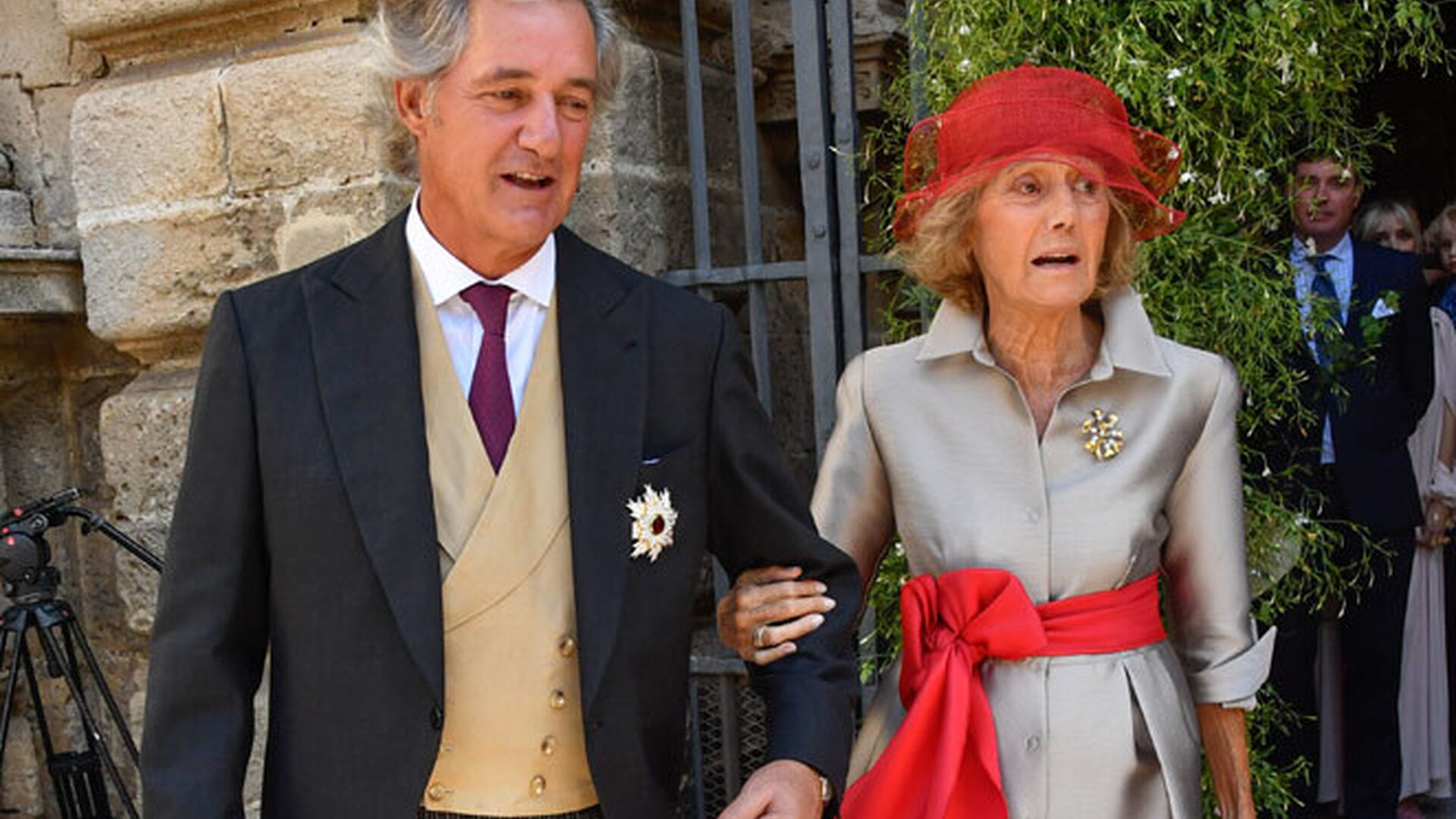 El padre del novio, Jos&eacute; Manuel Entrecanales Domecq, y su abuela, Blanca Domecq, con abrigo gris con cintur&oacute;n y tocado rojos.