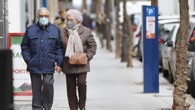 Dos onubenses pasean con sus mascarillas por un calle del centro de Huelva capital en el día de ayer.