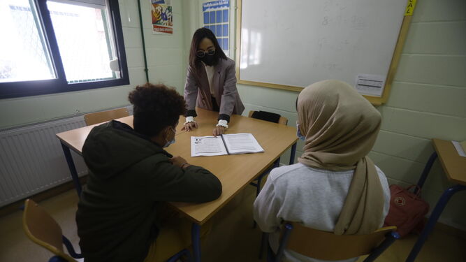 Una profesora de las Aulas de Adaptación Lingüística con dos alumnos inmigrantes.