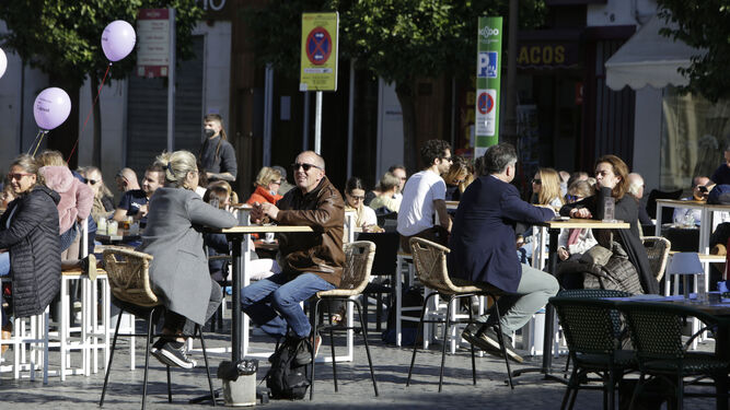 Un grupo de personas disfruta al sol en una terraza en Sevilla
