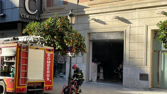 Los bomberos actúan en un incendio en la tienda Punto Roma del centro de Huelva.