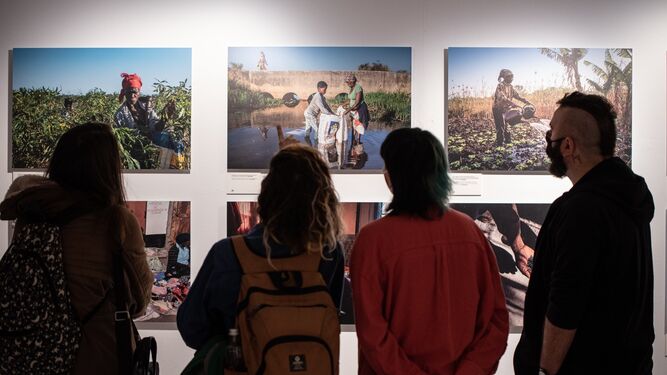 Visitantes miran imágenes de la exposición.