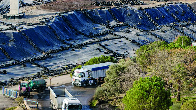 Dos camiones tras dejar su carga salen del vertedero de residuos tóxicos de Nerva.