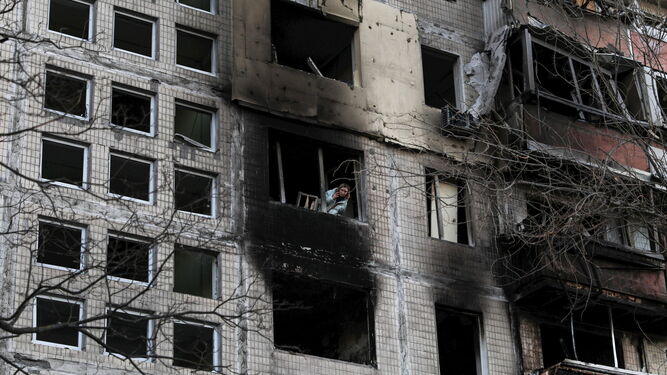 Una residente se asoma a la ventana de un edificio destruido por un bombardeo ruso en Kiev.