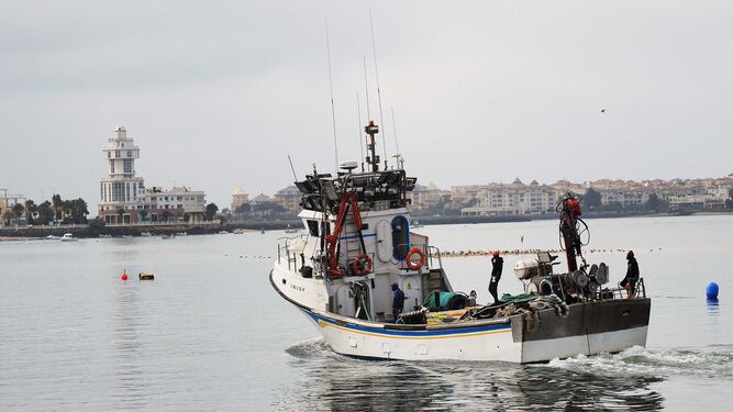 Una embarcación pesquera navega por el puerto de Isla Cristina justo el día antes de iniciarse el paro