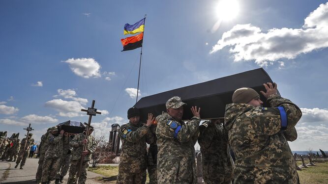 Soldados portan féretros de ucranianos sin nombre