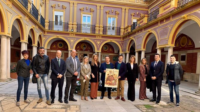 Organizadores, patrocinadores, participantes y colaboradores de la Feria del Libro con el cartel de esta edición en el Ayuntamiento de Huelva.