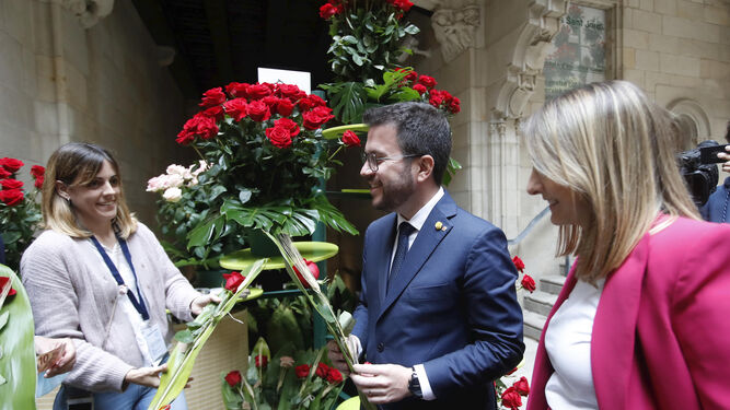 Pere Aragonès, y su pareja Janina Juli Pujol (d), reciben una rosa por el Día de Sant Jordi