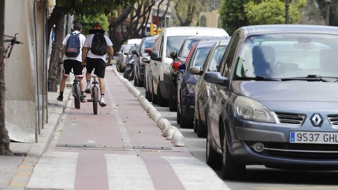 Dos jóvenes en el carril bici de Huelva en la mañana de ayer.