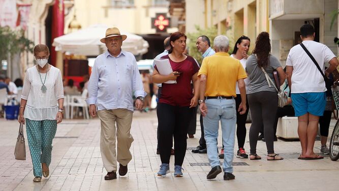 Varias personas pasean por una calle céntrica de Huelva.