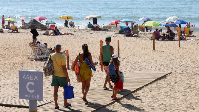 Bañistas llegan a la playa de La Antilla.